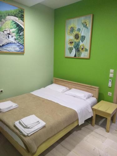 sypialnia z łóżkiem i zieloną ścianą w obiekcie Anastasios Luxury Apartment Sea View w Retimnie