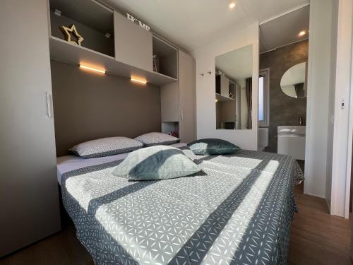 a bedroom with a bed with two pillows on it at Mobile Homes Relax Park Umag in Umag