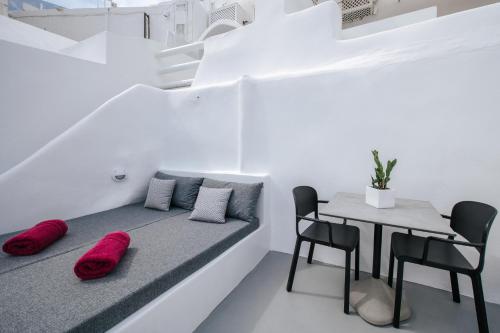 a room with a bed and a table and chairs at Virginia's Cave Villas in Oia