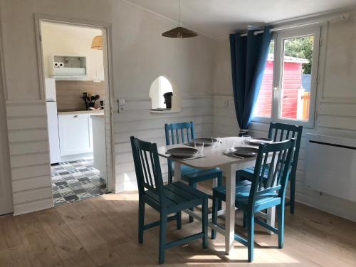 une cuisine et une salle à manger avec une table et des chaises dans l'établissement La ptite maison de Royan pour 4 personnes avec jardin, à Royan