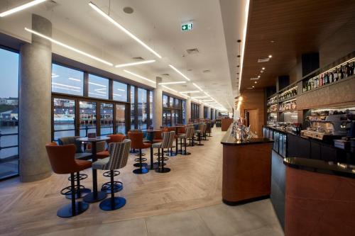 a bar with a row of bar stools in a restaurant at Tŷ Milford Waterfront in Milford Haven