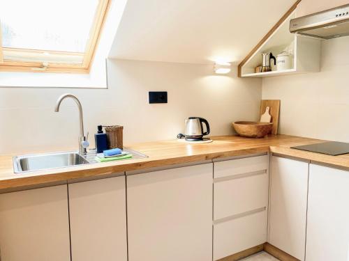 a kitchen with white cabinets and a sink at Apartamenty Maria Magiera in Sromowce Niżne
