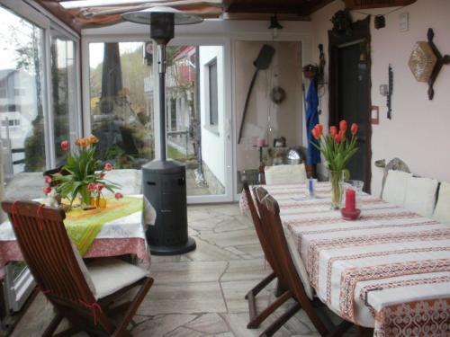 a dining room with a table with flowers on it at Haus Schipper am Wald in Gemünden