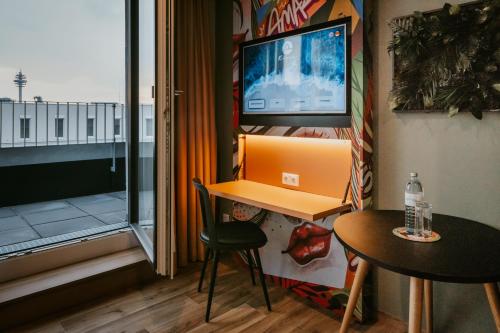 a room with a desk with a laptop and a table at Rioca Vienna Posto 2 in Vienna