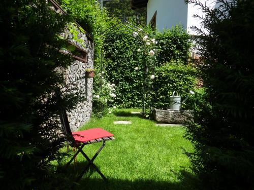 a red chair sitting in the grass in a garden at Haus Christopherus in Klösterle am Arlberg
