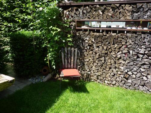 a chair sitting in the grass next to a stone wall at Haus Christopherus in Klösterle am Arlberg