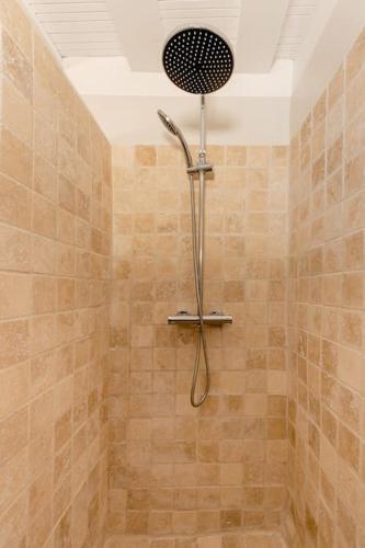 une douche avec pommeau de douche dans une salle de bain dans l'établissement La Majorquine Arles Arènes, à Arles