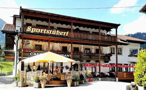 a building with an umbrella in front of it at Appartements Sportsüberl in Berwang