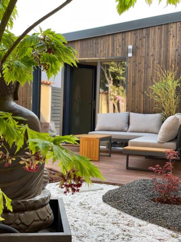 a patio with a couch and a table at Le GENKI japonais 4 étoiles in Saint-Cyr-sur-le-Rhône