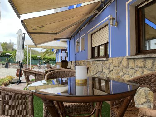 a patio with a glass table and chairs at Hotel Avelina in Cangas de Onís
