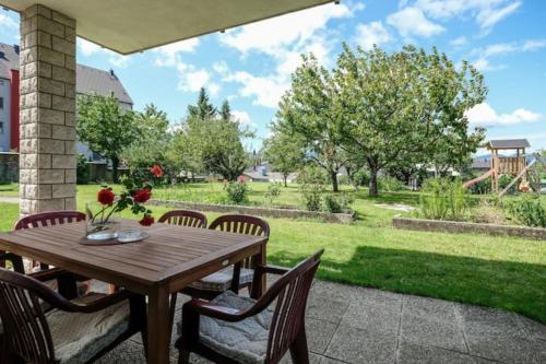 un tavolo e sedie in legno su un patio di Central Garden House (family friendly!) a Postumia