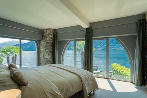 a bedroom with a bed and a large window at Villa Sasso on Lake Como by Rent All Como in Sala Comacina