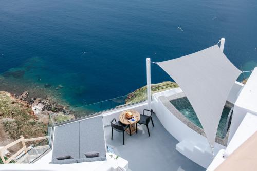a view of the ocean from the balcony of a house at Virginia's Cave Villas in Oia