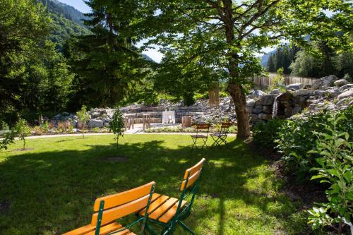a park bench sitting in the grass under a tree at Haus Christopherus in Klösterle am Arlberg