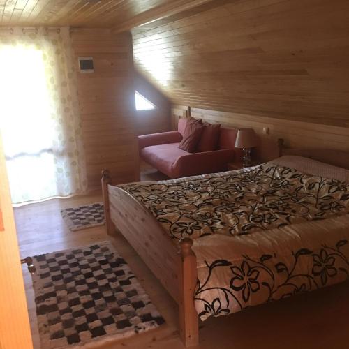 ein Schlafzimmer mit einem Bett und einer Couch in der Unterkunft Casa Cris in Durau