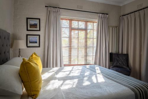 a bedroom with a large bed and a window at 17Peppertree in Cape Town