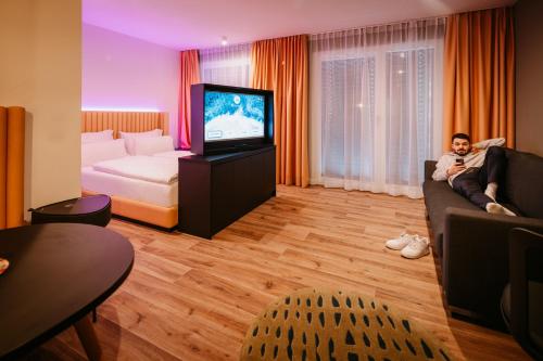 a man sitting on a couch in a hotel room at Rioca Vienna Posto 2 in Vienna
