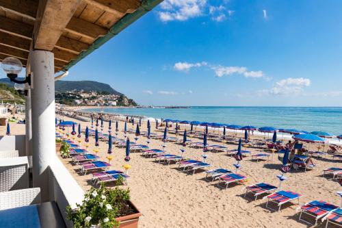 einen Strand mit Liegestühlen und Sonnenschirmen und dem Meer in der Unterkunft Casabianca Appartamenti in Numana