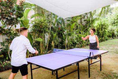 a man and woman playing a game of ping pong at TROPICAL HOUSE - Jungleside Villa in Hikkaduwa