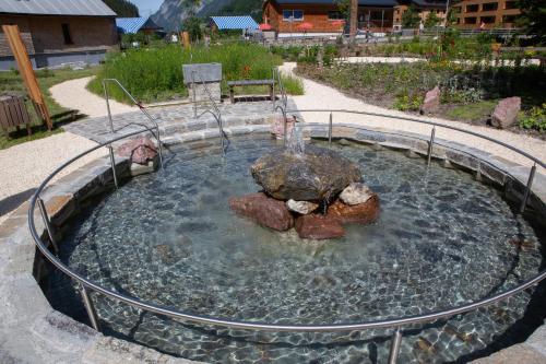 a fountain in a pool of water with rocks at Haus Christopherus in Klösterle am Arlberg