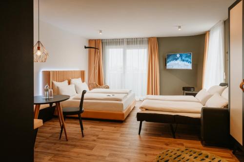 a hotel room with two beds and a table at Rioca Vienna Posto 2 in Vienna