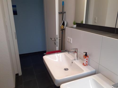 a bathroom with a white sink and a mirror at Ferienwohnung Marek in Friedrichshafen