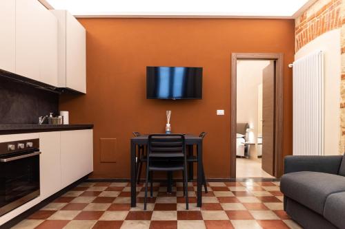 a kitchen with a table and a tv on the wall at ROMA PREMIUM in Casale Monferrato