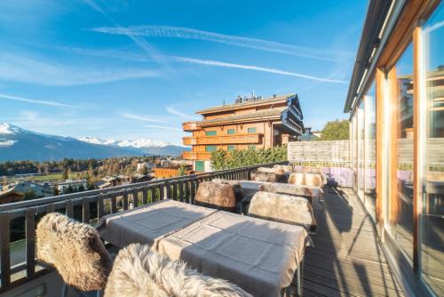 a balcony with a table and chairs on a building at Boutique Hotel Art de Vivre & SPA in Crans-Montana