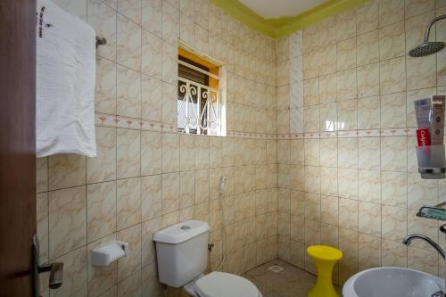 a bathroom with a toilet and a sink at The Crested Crane Bwindi Hotel in Rugando