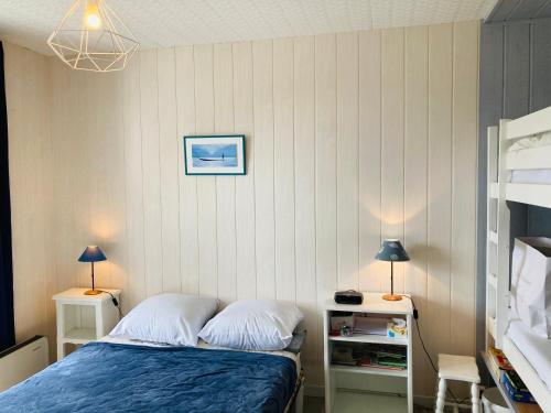 um quarto com uma cama e duas mesas e dois candeeiros em Maison des loriots, charme marin, plage à 100m em Saint-Jean-de-Monts
