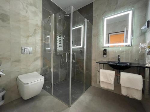 y baño con ducha, aseo y lavamanos. en Hotel Deutsches Haus en Cuxhaven
