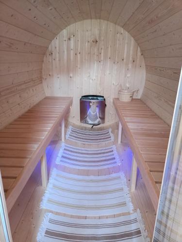 an inside of a sauna with two benches and a stove at Pensiunea ARC Bucovina in Vama