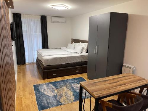 1 dormitorio con cama, mesa y armario en Princess - free parking place in the garage en Belgrado