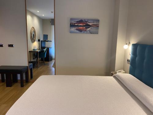 a living room with a bed and a table at Hotel Playa de Laxe in Laxe
