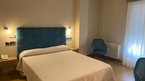 a hotel room with a bed and a chair at Hotel Playa de Laxe in Laxe