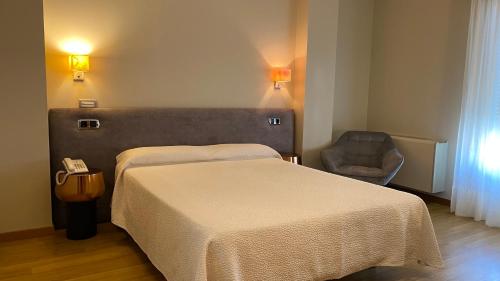 a hotel room with a bed and a chair at Hotel Playa de Laxe in Laxe