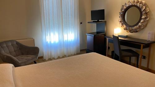a bedroom with a desk and a chair and a mirror at Hotel Playa de Laxe in Laxe