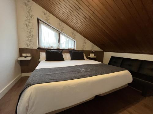 a bedroom with a large bed and a window at Hotel Avelina in Cangas de Onís
