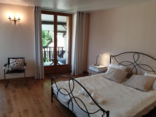 a bedroom with a bed with white sheets and a window at Maison des pêcheurs vue lac a 50m du port dans quartier historique in Thonon-les-Bains