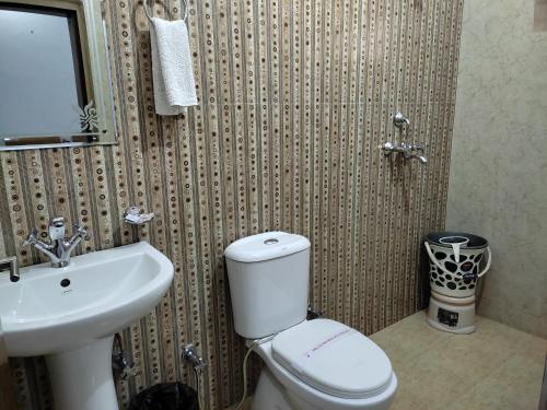 a bathroom with a white toilet and a sink at Hotel Krishna Ji in Haridwār