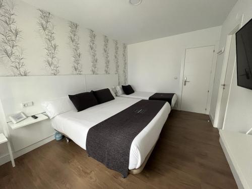 a hotel room with a large white bed in it at Hotel Avelina in Cangas de Onís