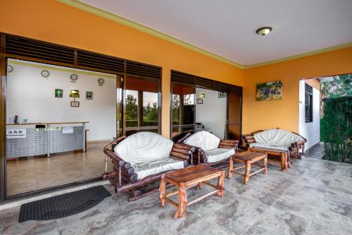 a living room with two chairs and a table at The Crested Crane Bwindi Hotel in Rugando
