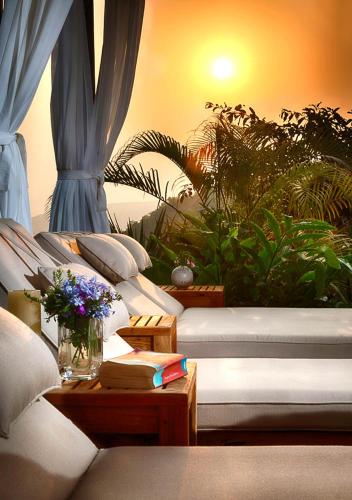 a group of couches in a room with plants at Kahani Paradise in Gokarna