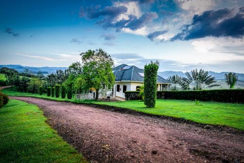 a house with a dirt road in front of it at The Crested Crane Bwindi Hotel in Rugando