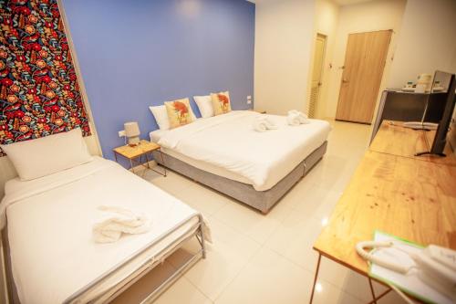 a room with two beds and a table with towels at iRabbit Hotel in Prachin Buri