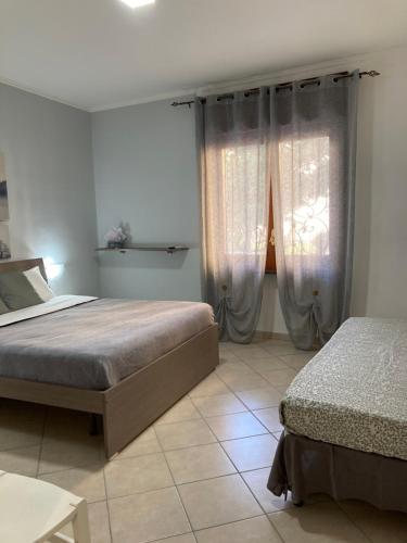 um quarto com 2 camas e uma janela com cortinas em POMPEI FELIX em Pompeia