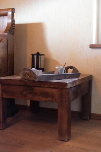 a wooden table with a tray with two cups on it at La Grange in Aymavilles