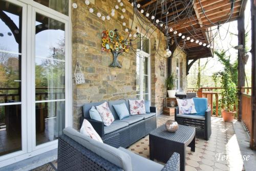 un patio avec des canapés et des chaises sur un mur en briques dans l'établissement Hôtel l'Ecrin d'Ô, à Spa