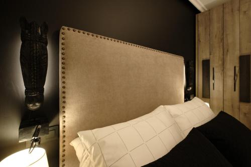 a bedroom with a headboard and a bed with white pillows at El Balconcillo - Apartamento boutique en pleno centro - Grupo Querbes in Gijón