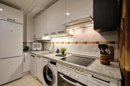 a kitchen with a sink and a washing machine at El Balconcillo - Apartamento boutique en pleno centro - Grupo Querbes in Gijón